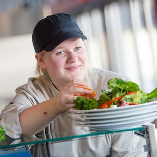 Das Bild zeigt eine auszubildende Köchin