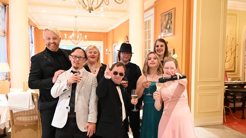 Hübsch und gestylt steht die Gruppe in einem Bankettsaal im Luxushotel und startet in ihren Gala-Abend (v.l.n.r Ross, Jonas, Patrick, Julius, Giuliana, Nicole, Rosalie)