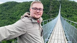 Yannis steht ans Geländer der Geierlaybrücke gelehnt