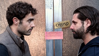 Zuerst hat es gebrannt und jetzt ist das Lokal geschlossen, weil Pipo (Adam Bousdoukos, r.) angeblich die Versicherung betrügen wollte. Dabei sind Luca (Giovanni Funiati, l.) und Pipo eigentlich gar nicht gegen Brand versichert.© SWRPolyphon PicturesMarkus Fenchel