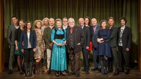 Gruppenbild von 2014, Familienfoto im Nebensaal der Dorfkneipe „Löwen“ (v.li.n.re.): Matthias (Markus Pfeiffer), Sophie (Janina Flieger), Jenny (Julia Obst), Bea (Christiane Brammer), Kati (Christiane Bachschmidt), Karl (Peter Schell), Johanna (Ursula Cantieni), Bernhard (Karsten Dörr), Hermann (Wolfgang Hepp), Heinz (Thomas Meinhardt), Monique (Anne von Linstow), Franz (Edgar-M. Marcus), Eva (Lucy Muhr), Andreas (Ralph Gassmann) und Albert (Alessio Hirschkorn). © SWRStephanie Schweigert