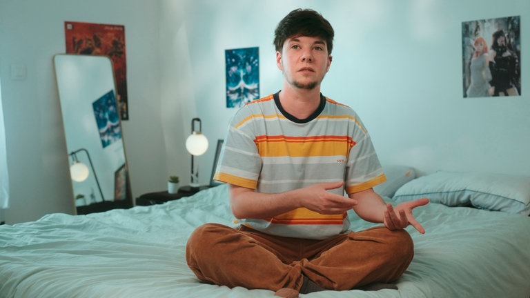 Jules, auf dem Bett sitzend, erzählt von seinen Erfahrungen bei Ubisoft