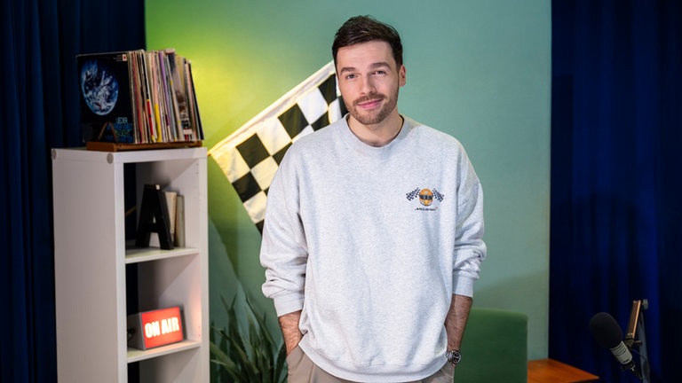 Max Dehling, Host und Autor von "Höllenrausch" in der Podcast-Kulisse mit einer „chequered flag"