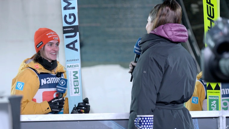 Skispringerin Selina Freitag (li.) beim Interview mit Moderatorin Lea Wagner nach dem Sieg im Mixed Springen am 22.11.2024 in Lillehammer