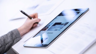 Ein Tablet mit der offenen Gremienseite liegt auf dem Tisch.