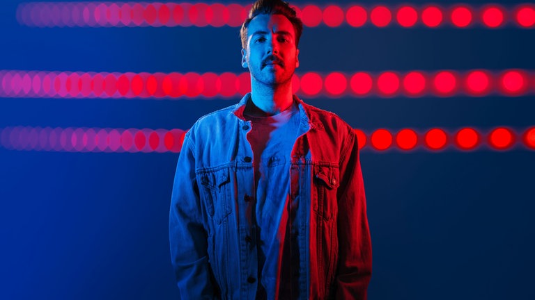 DJ FeBo vor blau rotem Hintergrund