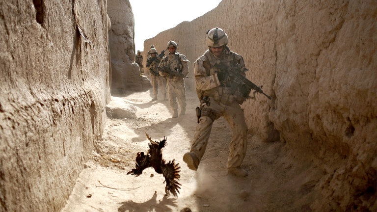 Salavat (Kandahar), Afghanistan, 2010: Ein kanadischer Soldat jagt ein Huhn – Sekunden bevor seine Einheit von Granaten beschossen wird.
