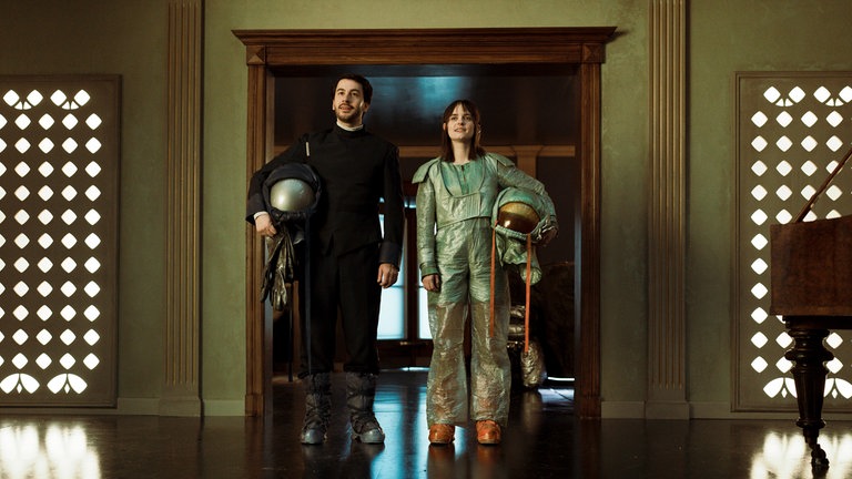Vanessa Loibl (re.) als Weltraumhotelerbin Nia und David Brizzi (li.) als Androide Adam in der Serie „The Stardust Hotel“.