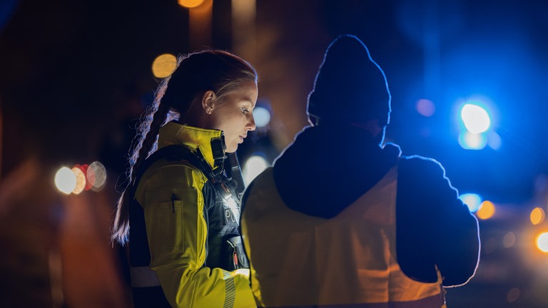 Polizistin Sarah Schraeder (li.) sichert mit einem Kollegem einen Unfallort bei Nacht.