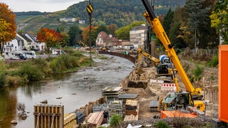 Blick auf die Ahr, rechts am Ufer steht ein Kran, es sieht alles sehr unfertig aus.