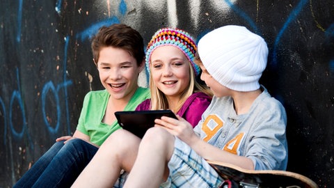 Drei Teenager mit Tablet
