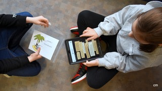 Zwei Kinder beim Lösen einer Tablett-Aufgabe bei der Büchereirallye