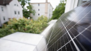 Ein Balkonkraftwerk hängt an einem Balkon. Die Zahl der Solaranlagen für den Balkon ist zuletzt noch einmal stark gestiegen. Der nächste Schub könnte folgen: Die Installation wird jetzt einfacher durch ein neues Gesetz.