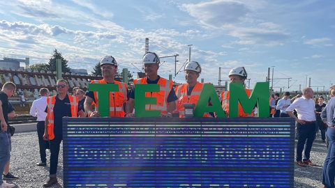 Bauarbeiter drücken den Buzzer vor dem Start der Generalsanierung der Riedbahnstrecke von Mannheim nach Frankfurt.
