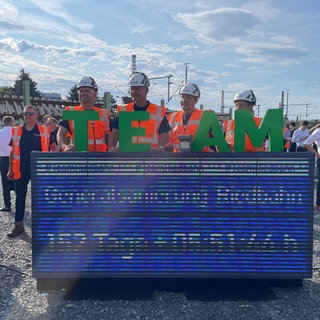 Bauarbeiter drücken den Buzzer vor dem Start der Generalsanierung der Riedbahnstrecke von Mannheim nach Frankfurt.