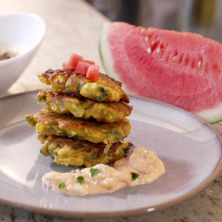 Auf dem Bild sind angeschnittene Melonen und Kichererbsenpuffer mit Dipp zu sehen. Kichererbsenpuffer mit Dipp sind ein leckeres Gericht für warme Sommertage. Das Rezept eignet sich perfekt, um eine Wassermelonenschale zu verwerten.