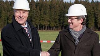 Franz und Bernhard beim ersten Spatenstich auf der Großbaustelle - sie lachen beide in die Kamera