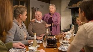 Leni hat Josef Zimmermann, der mit Johanna und den Landfrauen am Küchentisch sitzt, den Arm um die Schulter gelegt