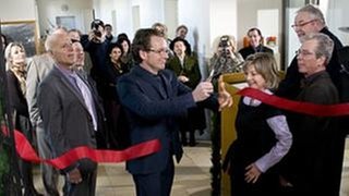 Bernhard durchschneidet das rote Band bei der Eröffnung des Heimatmuseums