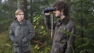 Sebastian und Albert im Wald, Albert schaut durch ein Fernglas