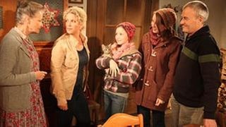Johanna, Bea, Annika, Lena und Karl stehen in der Fallersküche, Annika hat ein kleines Kätzchen im Arm