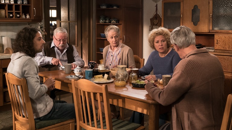 Die Familie sitzt gemeinsam beim Frühstück