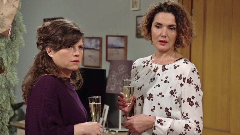 Eva und Monique, jede hat ein Sektglas in der Hand