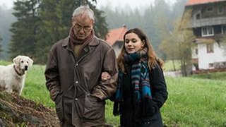 Karl und Jenny gehen spazieren, im Hintergrund sieht man Willy, den Hofhund