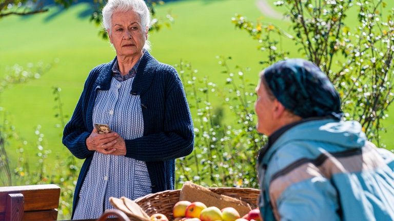 Johanna und Lioba mit Obstkörben hinterm Hofladen