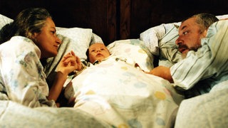 Johanna und Hermann haben den kleinen Albert zwischen sich im Bett liegen