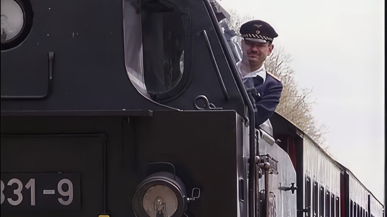 Der Lokführer blickt aus dem Führerstand.