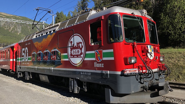 Lok Ge 44 II der Rhätischen Bahn mit der Geburtstagswerbung 50 Jahre LGB und dem Modell.