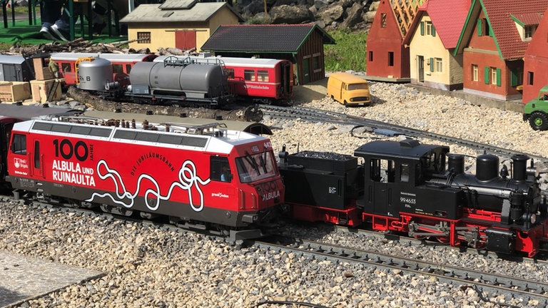 Eine E Lok der Rhätischen Bahn mit der Werbung für 100 Jahre Albubahn und Rheinschlucht.