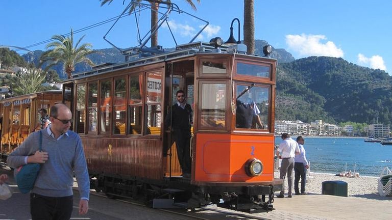 An der Uferpromenade von Port de Sóller entlang fährt die Straßenbahn zu ihrer Endstation.