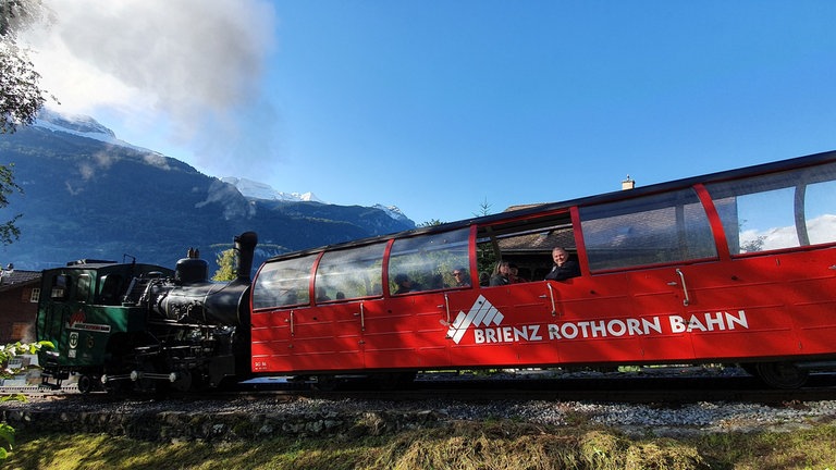 Die Brienz-Rothorn-Bahn mit der ölbefeuerten Lok 15 auf den ersten Metern der Gebirgsstrecke – noch sind die Häuser von Brienz zu sehen.