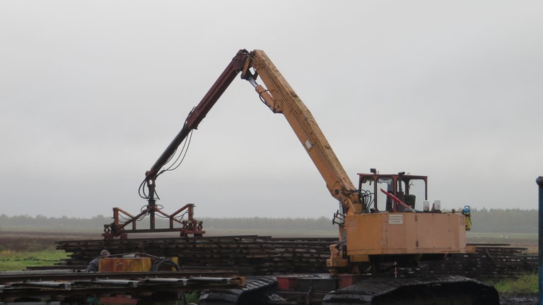 Gleisbau im Moor war früher Handarbeit; heute helfen Bagger, die Gleise zu verladen.