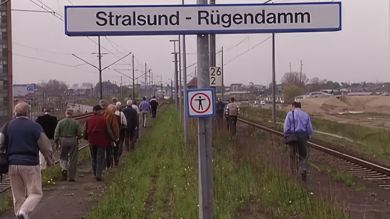 Fahrgäste warten an der Haltestelle "Stralsund-Rügendamm"