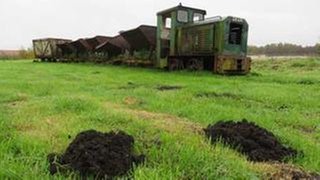 Eine ausgediente Moorbahn auf einem Feld neben dem Küstenkanal
