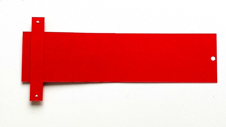  Einen dünnen Klebestreifen an das Ende des Ziehers anbringen. Darauf achten, dass der Klebestreifen nur auf dem "Zieher" und nicht auf dem Kärtchen ist.