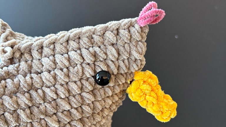 Den Kamm direkt auf die ersten bzw letzten 7 Maschen obere Kante häkeln, dafür Faden in Rot anmaschen.