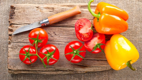 Paprika und Tomate auf einem Brettchen