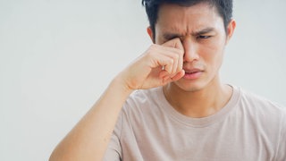 Trockene Augen: Mann reibt sich die Augen