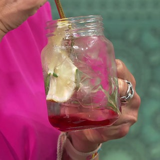 Moderatorin Evelin König trinkt einen alkoholfreien Cocktail