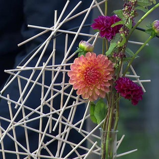 Eine herbstliche Blumendeko mit einer Schaschlikspieß-Skulptur
