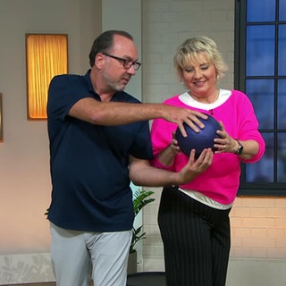 Moderatorin Heike Greis und Fitnesstrainer Stephan Müller machen Übungen mit einem Ball