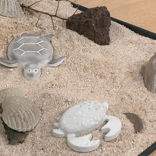 Betonfiguren im Sand