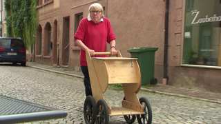 Mann schiebt einen Einkaufscaddy aus Holz