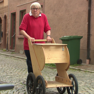 Mann schiebt einen Einkaufscaddy aus Holz