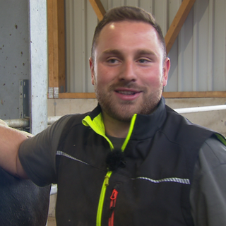 Jungbauer steht im Stall