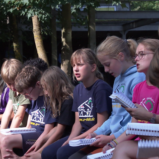 Kinder singen am Lagerfeuer